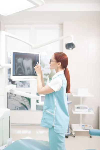 Рудий стоматолог з хвостиком вивчає рентген пацієнта — стокове фото