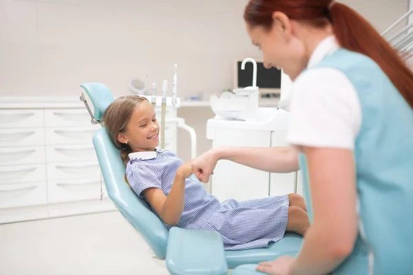 Χαμογελαστή κορίτσι χαιρετισμό ευχάριστη οδοντιατρική θεραπευτή της — Φωτογραφία Αρχείου