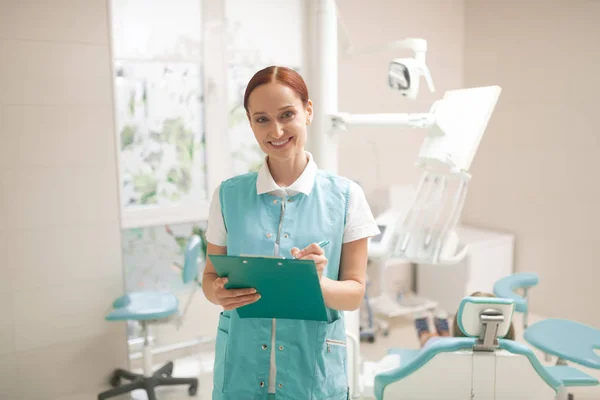 Child dentist smiling while standing in the dentist room