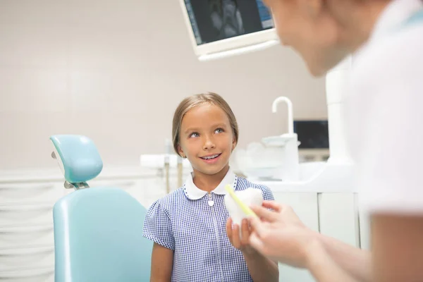 Dentista infantil contándole a la niña sobre salud dental — Foto de Stock