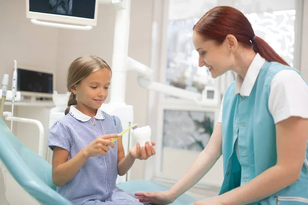 Doktor mówi dziewczynie o znaczeniu opieki stomatologicznej — Zdjęcie stockowe