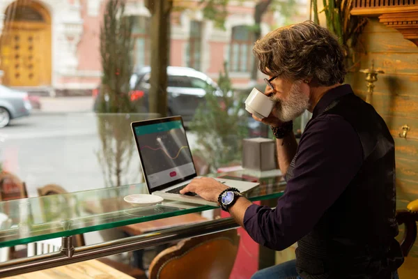 Knappe man genieten van zijn koffie en werken. — Stockfoto