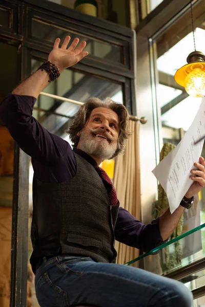 Cheerful bearded man calling a waiter over. — Stock Photo, Image