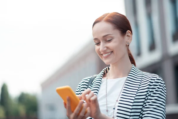 Smiling young female entrepreneur in a striped jacket