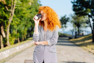 Büyüleyici kızıl saçlı kız lezzetli kahve içme