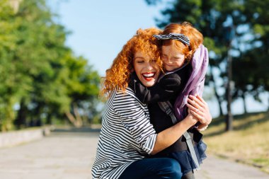 Çocuğunu kucaklayan pozitif memnun bekar ebeveyn