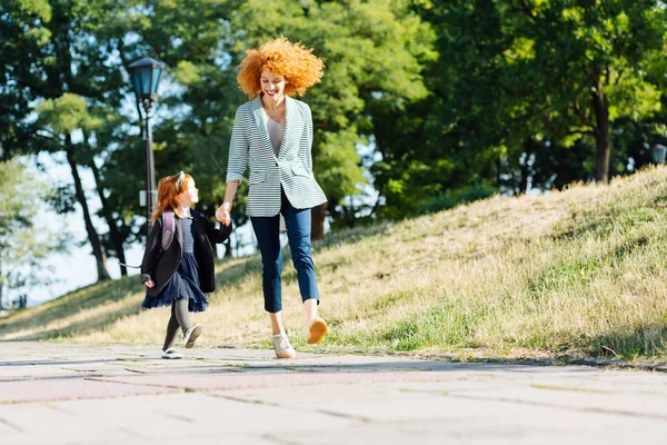 Glad mamma och dotter hoppar när du går — Stockfoto