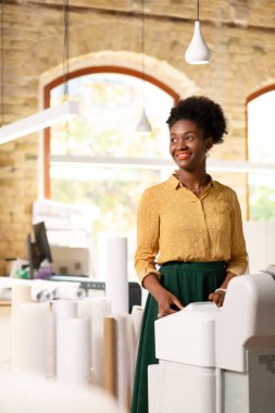 Ofiste kağıt rulo yanında duran motive ofis çalışanı