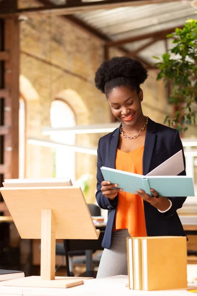 Kitap kapakları tasarlarken yayınevinin çalışanı gülümseyerek