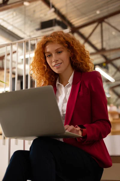 Zakenvrouw het lezen van e-mails op laptop terwijl zittend op de trap — Stockfoto