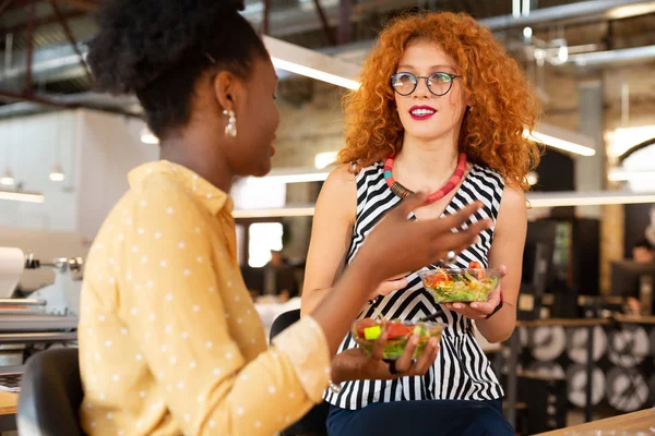 Mulher usando colar comendo salada com colega — Fotografia de Stock