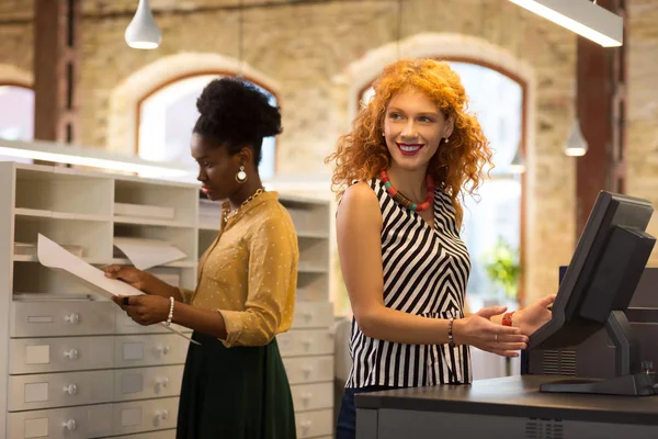 Kaşer masasında zıpkınlanan kızıl saçlı genç iş kadını