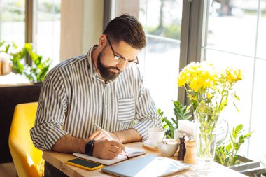 Defterine yazan ciddi sakallı adam