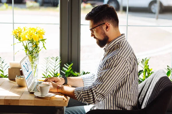 Knappe serieuze man werken aan zijn laptop — Stockfoto