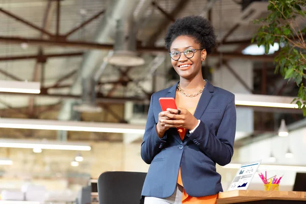 Kvinna som innehar röd smartphone medan textning pojkvän — Stockfoto