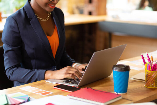 Дизайнер интерьера пьет кофе и работает с ноутбуком
