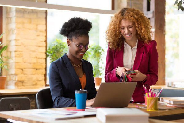 Дизайнер интерьера улыбается, работая вместе над одним проектом
