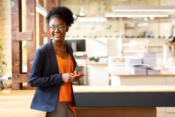 Mooie vrouw. Mooie donker gevilde vrouw met oranje blouse en donker jasje glimlachend — Stockfoto