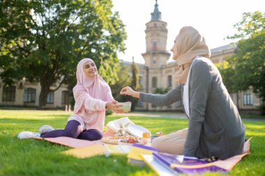 Arkadaşıyla öğle yemeği yerken bazı çilek alarak Kadın