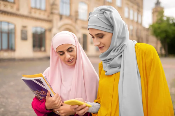 Teman terbaik menunjukkan foto di smartphone untuk siswa muslim — Stok Foto