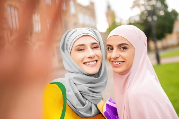 Female muslim students wearing hijabs smiling broadly — Stock Photo, Image