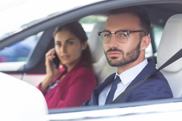 Esposo barbudo dirigindo carro enquanto esposa falando por telefone — Fotografia de Stock