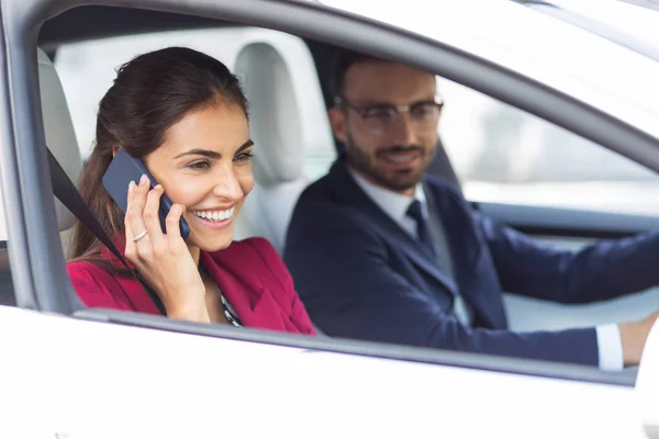 Χαρούμενη γυναίκα που μιλάει τηλεφωνικώς, ενώ ο σύζυγος οδήγηση — Φωτογραφία Αρχείου