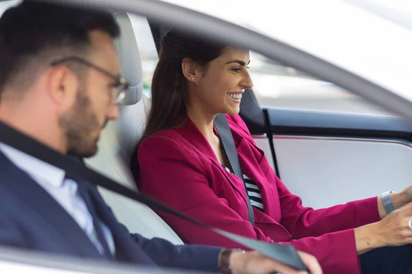 Επιχειρηματίας χαμογελά ενώ οδηγεί το αυτοκίνητο με τον άντρα που κάθεται κοντά — Φωτογραφία Αρχείου