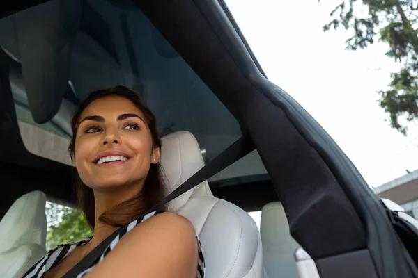 Mulher atraente de olhos escuros sentindo-se alegre enquanto dirige — Fotografia de Stock