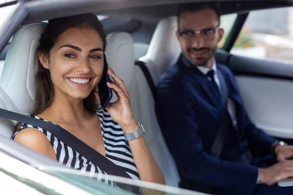 Mulher falando por telefone enquanto sentado perto do marido no carro — Fotografia de Stock