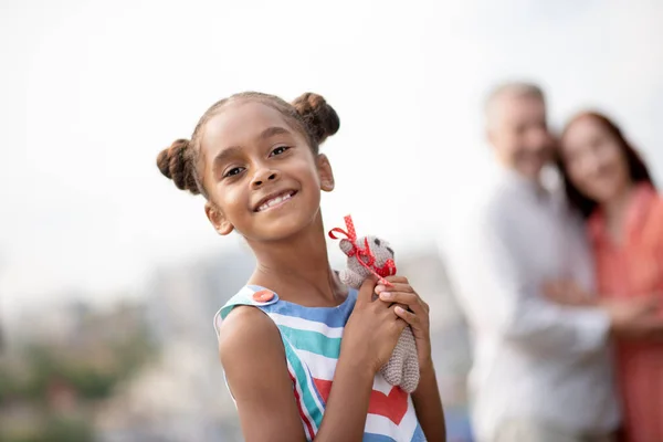 Hija de piel oscura sintiéndose feliz después de recibir el juguete — Foto de Stock