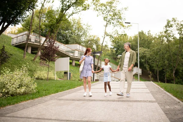 Ragazza afro-americana che cammina nel parco con i genitori — Foto Stock