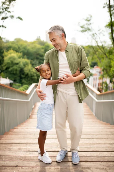 Amare ragazza adottata abbracciando il suo bel papà premuroso — Foto Stock