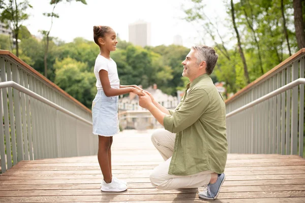 Весела дочка посміхається, розмовляючи з татом — стокове фото