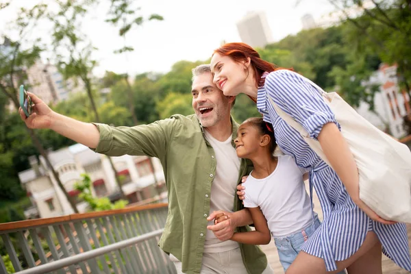 Padre de pelo gris haciendo selfie con esposa e hija — Foto de Stock