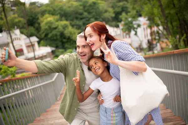 Familia alegre haciendo selfie mientras camina por la ciudad — Foto de Stock