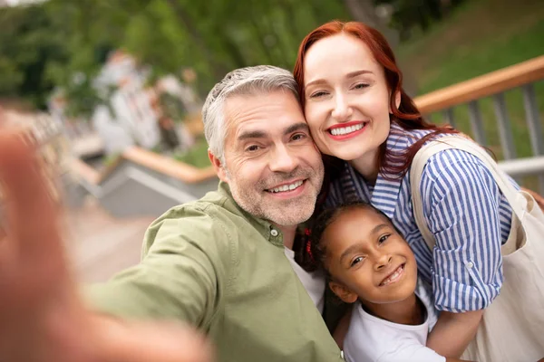 Pais e filha sorrindo amplamente enquanto posam para foto — Fotografia de Stock