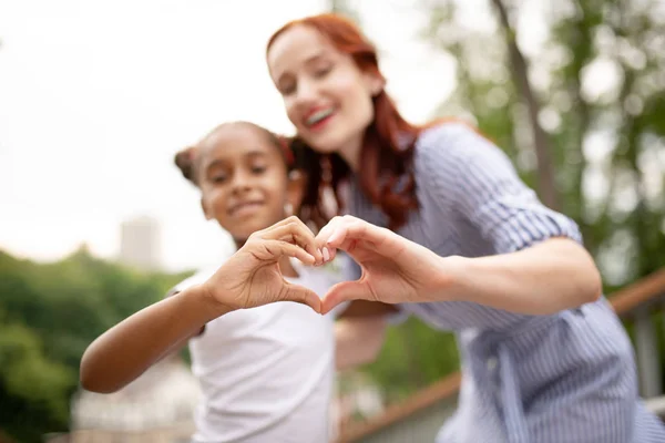Daughter and mother making heart with their hands — Stock Photo, Image