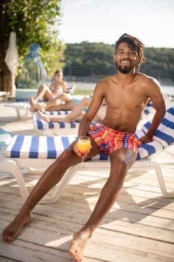 Dreadlocks hissi ile Afro-Amerikalı adam nehir yakınında dinlenmiş