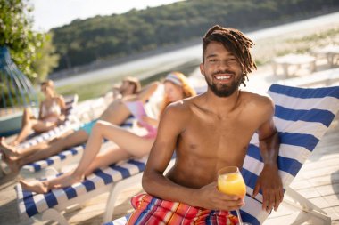 Sakallı Afro-Amerikalı adam arkadaşlarıile nehir yakınında rahatlatıcı