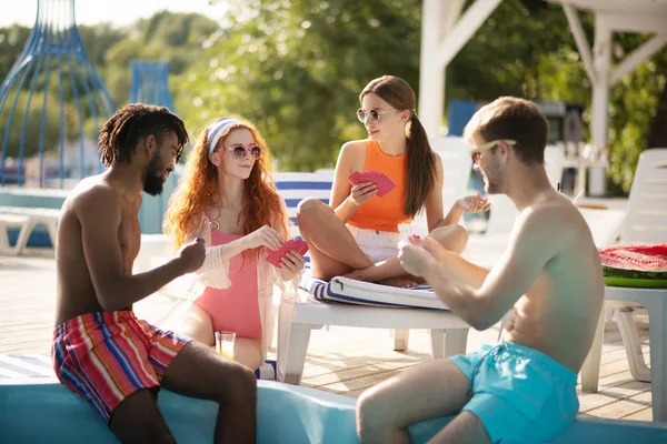 Les jeunes jouent aux cartes tout en se refroidissant près de la piscine — Photo