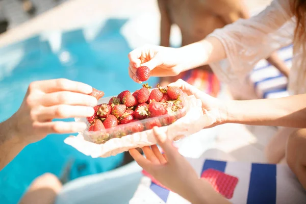 Amici che mangiano fragole mentre prendono il sole fuori — Foto Stock