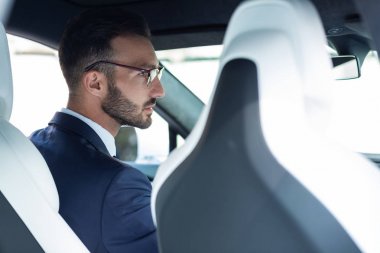 Yakışıklı genç adam işe giderken arabasını sürüyor