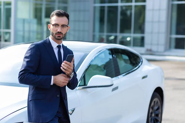 Businessman standing near car while waiting for wife — Stock Photo, Image