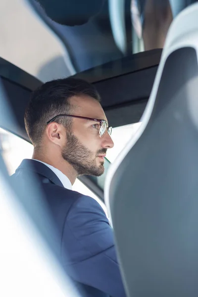 Handsome bearded man wearing glasses driving his car — Stock Photo, Image