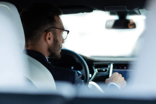 Bearded young man in glasses sitting in his car — Stock Photo, Image