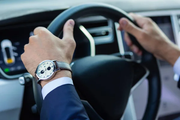 Close up of businessman holding steering wheel