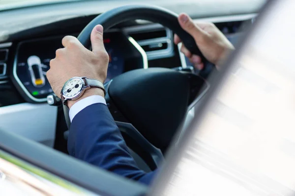 Biznesmen noszący rękę zegarek jazdy jego samochód w godzinach porannych — Zdjęcie stockowe