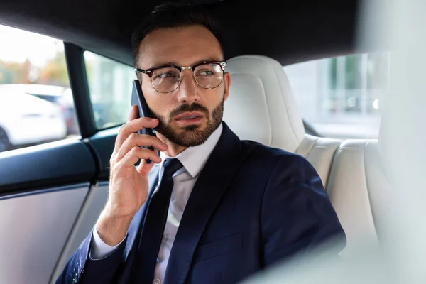 Businessman calling his business partner while sitting in car — Stock Photo, Image