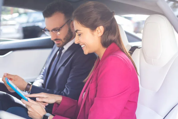 Couple of businessmen using tablet while sitting in the cat